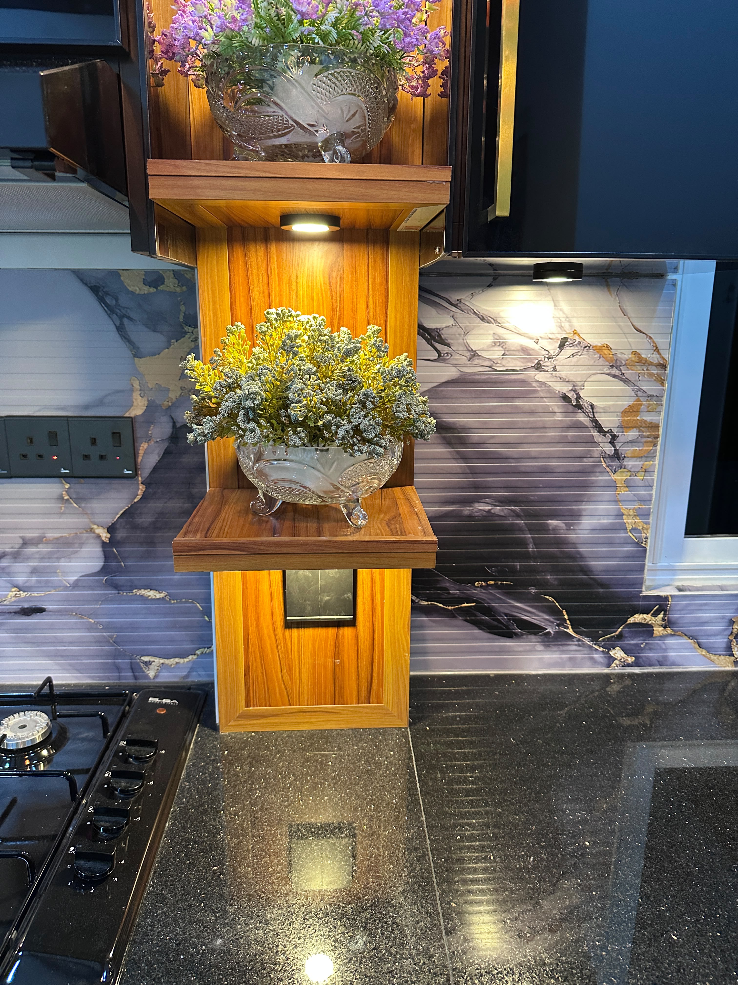 Wooden shelving with decorative items and marble backsplash